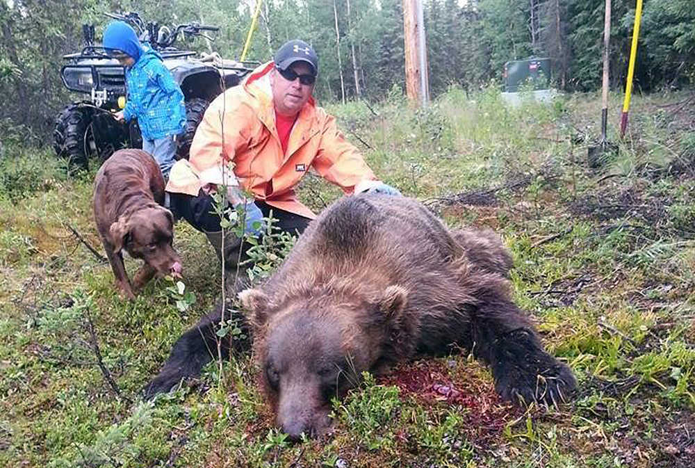 Photo courtesy Jim Landess Sterling resident Jim Landess kneels next to the 9-foot brown bear he killed after it attempted to break into his house on July 7.