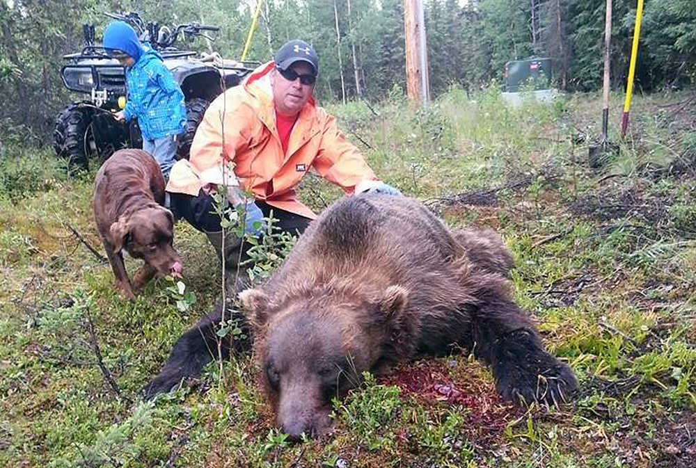 Photo courtesy Jim Landess Sterling resident Jim Landess kneels next to the 9-foot brown bear he killed after it attempted to break into his house on July 7.