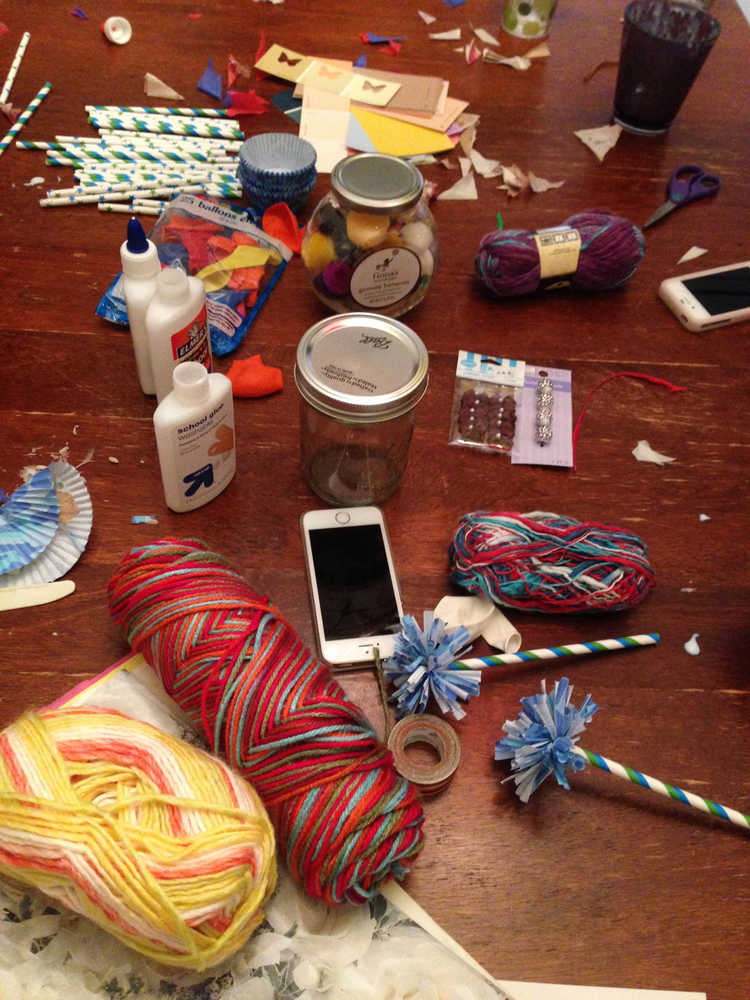 In this Thursday, July 3, 2014 photo, cell phones, mixed with the evening's supplies, were rarely touched at a crafting party for teenagers in Arvada, Colo. Crafting encourages creativity, develops imagination and counters the many hours teens spend on their computers, phones and other "screens." Activities such as crafting allow parents to connect with their teens in a healthy way.   (AP Photo/Jennifer Forker)