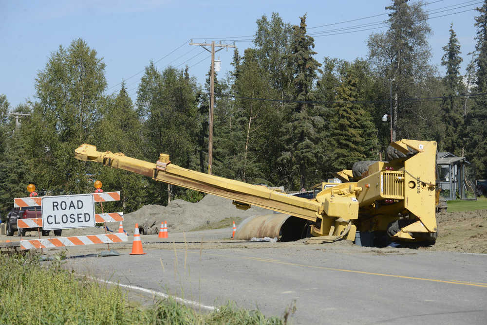 Photo by Rashah McChesney/Peninsula Clarion  An overturned crane sits in a ditch along Beaver Loop Road where Wednesday July 30, 2014 in Kenai, Alaska. Soldotna-based Endries Construction, the general contracter on a culvert replacement project along the road, was attemping to move a piece of the old culvert when the crane overturned according to the project engineer.