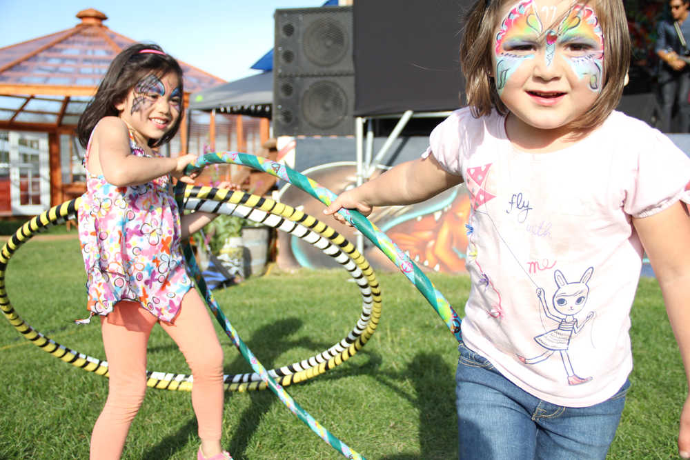 Miah Anthony, 5, of Kodiak, and her cousin Abby Samaniego, 4, of Fairbanks, play with hula hoops at Salmonstock on Friday in Ninilchik. Photo by Kaylee Osowski/Peninsula Clarion