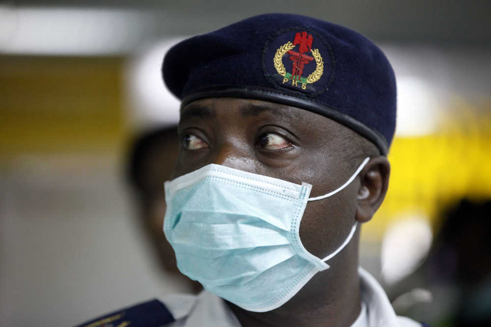 A Nigerian health official wearing a protective mask waits to screen passengers at the arrivals hall of Murtala Muhammed International Airport in Lagos, Nigeria, Monday, Aug. 4, 2014. Nigerian authorities on Monday confirmed a second case of Ebola in Africa's most populous country, an alarming setback as officials across the region battle to stop the spread of a disease that has killed more than 700 people. (AP Photo/Sunday Alamba)