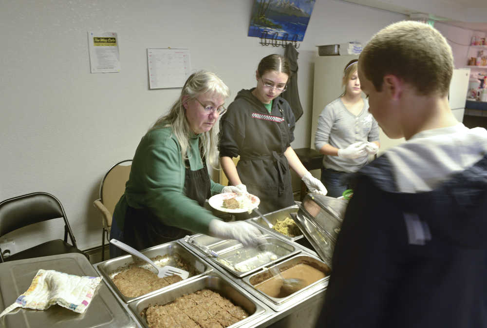 Photo by Rashah McChesney/Peninsula Clarion  Betsy Laws, Kiowa Richardson and Jaiden Streiff serve food at The Way Cafe Thursday September 12, 2013 in Kenai, Alaska.