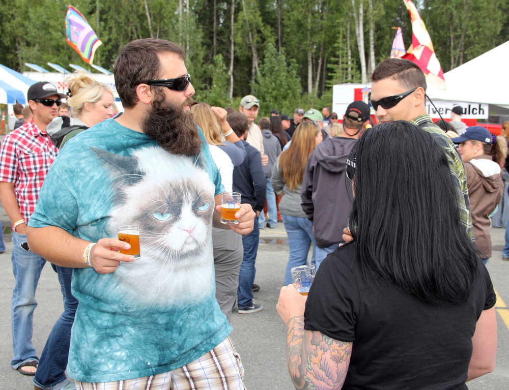 Photo by Dan Balmer/Peninsula Clarion Justin Miller from Anchorage grooves to the music while endulging in the "Hoppin' Salmon Wheat" from the Kenai River Brewing Company at the Kenai Peninsula Beer Festival in Soldotna Saturday. More than 15 breweries from all around the state participated in the festival, a fundraiser for the Rotary Club of Soldotna with benefits going to local Rotary projects.