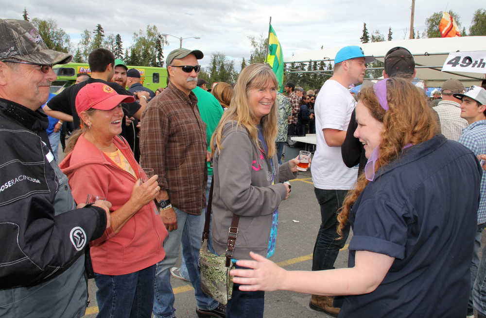 Photo by Dan Balmer/Peninsula Clarion Della McCarthy who works for the 49th State Brewing Company in Denali Park, talks about their beer selection to people waiting in line for a sample at the Kenai Peninsula Beer Festival Saturday in Soldonta. The brewery won the people's choice award for best beer for the 12-Quadruple, a dark Belgian ale with 10.5 percent alcohol that has notes of banana and caramel undertones. More than 15 breweries from all around the state participated in the festival, a fundraiser for the Rotary Club of Soldotna with benefits going to local rotary projects.