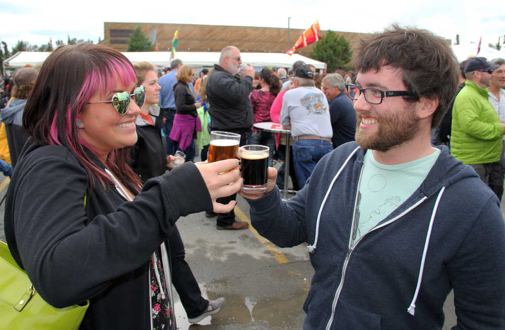 Photo by Dan Balmer/Peninsula Clarion Mandy Leslie of Anchorage beers with her brother Zack Leslie of Kenai at the Kenai Peninsula Beer Festival Saturday at the Soldotna Regional Sports Complex. Mandy Leslie said her favorite beer was the 12 Quadruple beer from the 49th State Brewing Company, which won as the people's choice for top beer. More than 15 breweries from all around the state participated in the festival, a fundraiser for the Rotary Club of Soldotna with benefits going to local rotary projects.