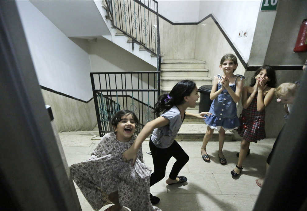 Restricted from playing outside, displaced Palestinian children play indoors in a high-rise building where their families had rented flats for them to live, after leaving their homes due to the unrest, in Gaza City, Sunday, Aug. 10, 2014. (AP Photo/Lefteris Pitarakis)