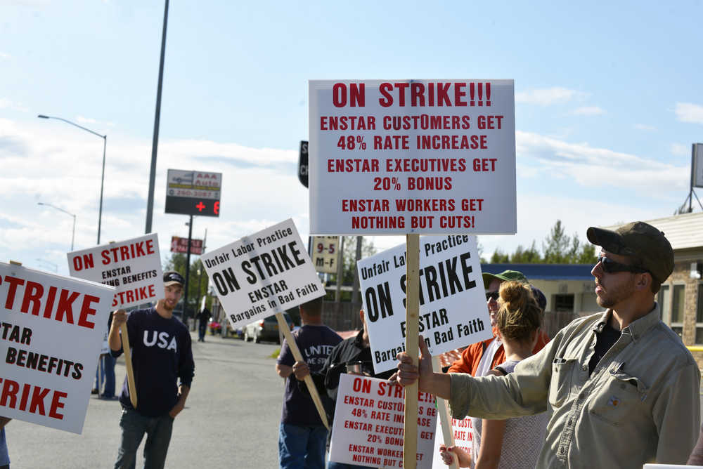 Photo by Dan Balmer/Peninsula Clarion ENSTAR employees picket in front of ENSTAR Natural Gas Company on the Kenai Spur Highway Monday in Soldotna. The 20 field workers and supporters from the Plumbers and Pipefitters Union Local 367 are part of statewide strike over failed negotiations for pension and health benefits.