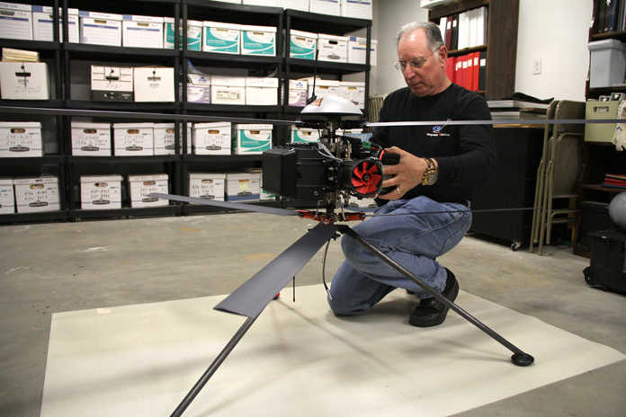 John Parker, president of Integrated Robotics Imaging Systems in Kenai, removes a more than 12-pound battery on Thursday from his Infotron coaxial rotor unmanned aerial vehicle, which recently arrived in Kenai from the France-based company. Parker is the North American representative for the company and returned from maintenance and flight training on the UAV in France about a month ago. Parker plans to integrate the UAV with collision avoidance radar developed at the University of Denver of which he has the exclusive patent rights. Photo by Kaylee Osowski/Peninsula Clarion