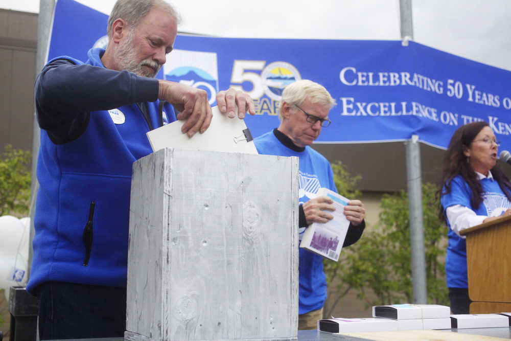 Photo by Kelly Sullivan/ Peninsula Clarion Kenai Peninsula College Direct Gary Turner places an item inside the mock-version of the 50th anniversary time capsul, which will eventually go inside the wall at KPC, during the Kenai Peninsula Borough, Kenai Peninsula College and Kenai Peninsula Borough School District joint 50th anniversary community barbecue, Thursday, August 14, at the KPC Kenai River Campus in Soldotna, Alaska.