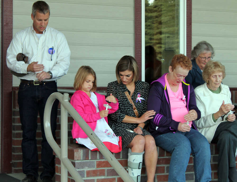 Photo by Dan Balmer/Peninsula Clarion Julia Selanoff (left) comforts Jeanine Adams after a candle light vigil at the New Life Assembly of God Church in Kenai Tuesday night. Adams is the mother of Rebecca Adams, who has been missing along with her two daughters and boyfriend Brandon Jividen for three months.