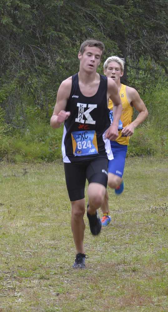 Photo by Jeff Helminiak Kenai Central's Jordan Theisen runs with Kodiak's Levi Fried right on his shoulder with less than a kilometer to go at the Tsalteshi Invitational at Tsalteshi Trails on Saturday. Theisen would beat Fried by five seconds for fifth place.