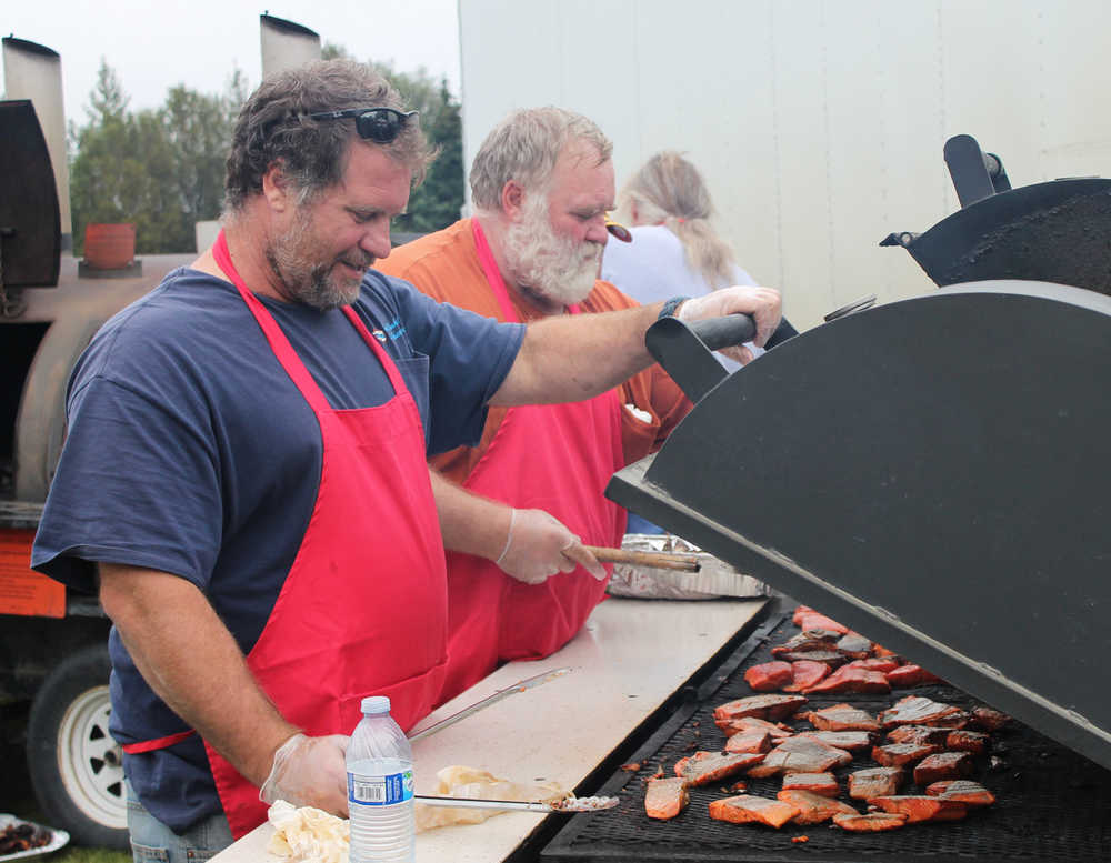 Richard Thompson, left, of Kenai, a United Cook Inlet Drift Association member, grills salmon with his father, Dan Thompson, for the crowd at Industry Appreciation Day Saturday in Kenai. The event recognizes the contributions of area industries, including fishing, oil and gas, and tourism, to the community.
