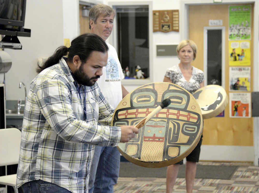 ADVANCE FOR USE MONDAY, AUG. 25 - In this Aug. 13, 2014 photo, Ed Littlefield, left, plays a deerskin drum with teachers as part of a Basic Arts Institute class at Ketchikan High School in Ketchikan, Alaska. The arts institute was brought to Ketchikan for the first time by a collaboration between the arts council, Ketchikan School District and the Alaska Arts Education Consortium. (AP Photo/Ketchikan Daily News, Taylor Balkom)