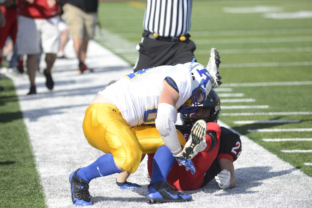 Photo by Kelly Sullivan/ Peninsula Clarion Kodiak High School's Elijah Squartsoff tackles Kenai Kardinal's Chase Gillies, Saturday, August 30, 2014 during the varsity game at Kenai Central High School in Kenai, Alaska.