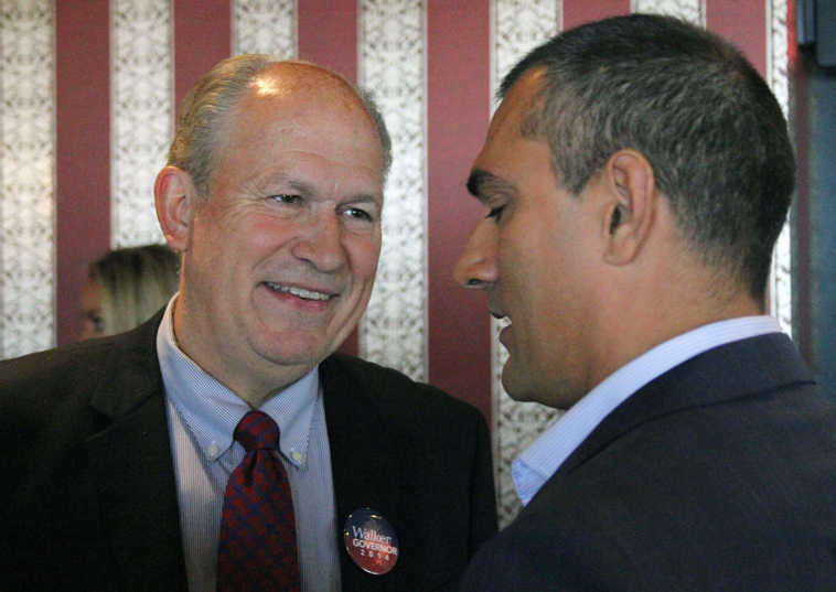 Alaska gubernatorial candidate Bill Walker, left, talks with his former running mate, Craig Fleener, before a news conference, Tuesday, Sept. 2, 2014, in Anchorage, Alaska. Walker will join with the former Democratic gubernatorial candidate, Byron Mallott, in a unified ticket to face Republican Gov. Sean Parnell in the general election.  Fleener stepped aside to let Mallott be the lieutenant governor candidate. (AP Photo/Mark Thiessen)