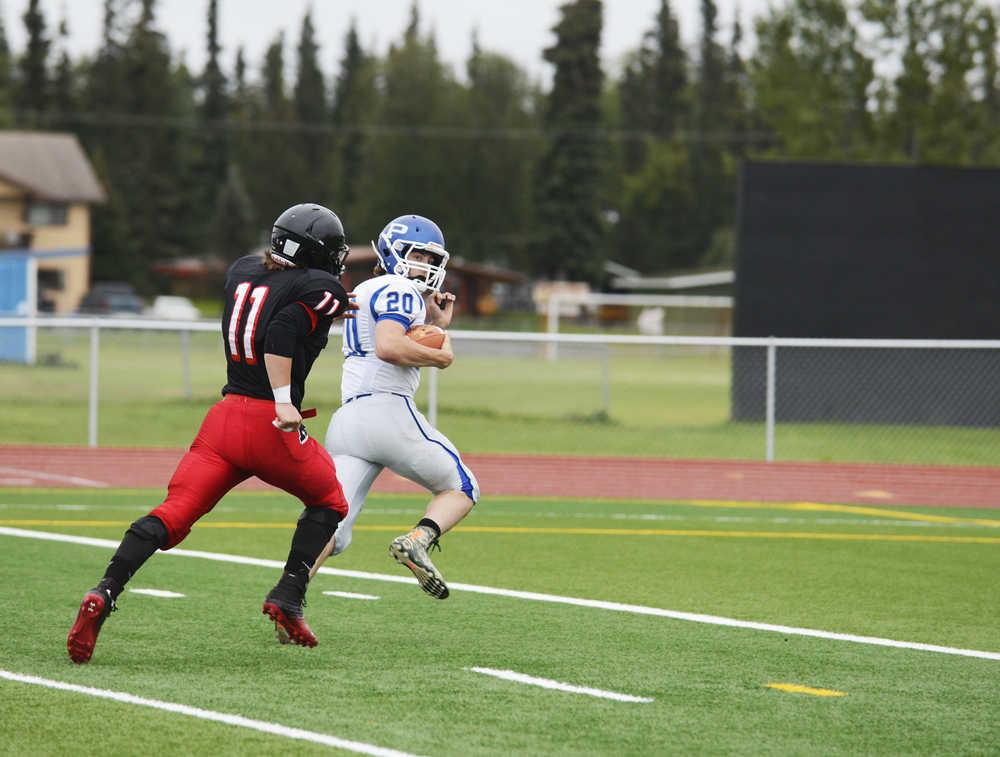 Photo by Kelly Sullivan/ Peninsula Clarion Kenai Central High School Kardinal's Number 40 Kyle Foree attempts to tackle, Palmer High School's Number 20 Tom Adams or Number 20 Chase Ferris, Friday, August 6, 2014, at Kenai Central High School in Kenai Alaska.