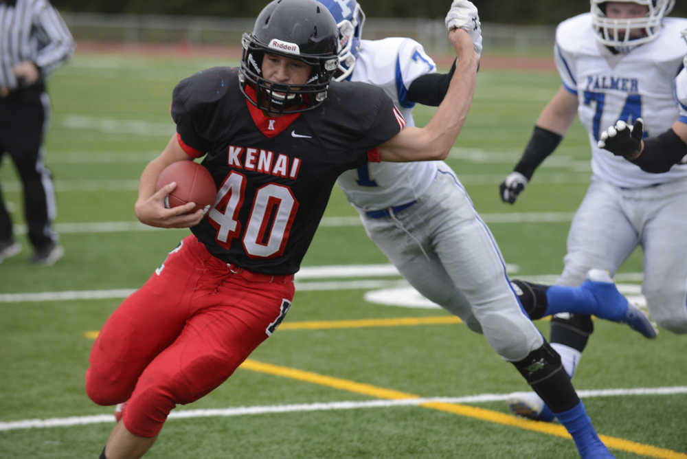 Photo by Kelly Sullivan/ Peninsula Clarion Kenai Central High School Kardinal's Number 40 Kyle Foree avoids a tackle from Palmer High School' Number 7 Kohei Watanabe or Number 7 Nathan Reeves, Friday, August 6, 2014, at Kenai Central High School in Kenai Alaska.