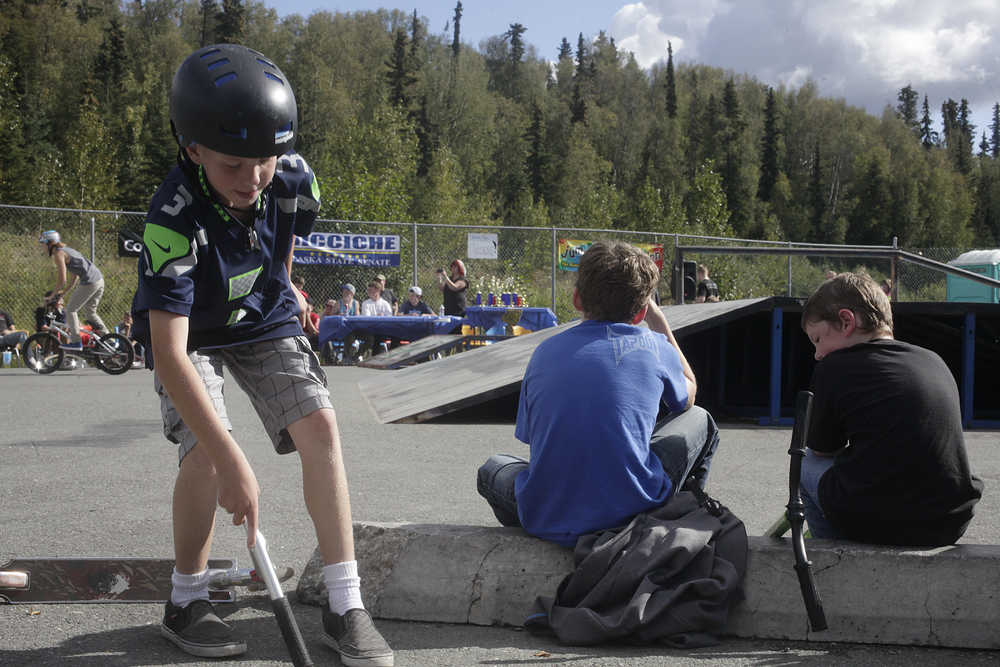 Photo by Rashah McChesney/Peninsula Clarion  Brady Baker grabs his scooter and takes off during a the BMX biking competition portion of the 5th Annual Bike & Skate Challenge Saturday Sept. 6, 2014 iat the Soldotna Skate Park in Soldotna, Alaska.