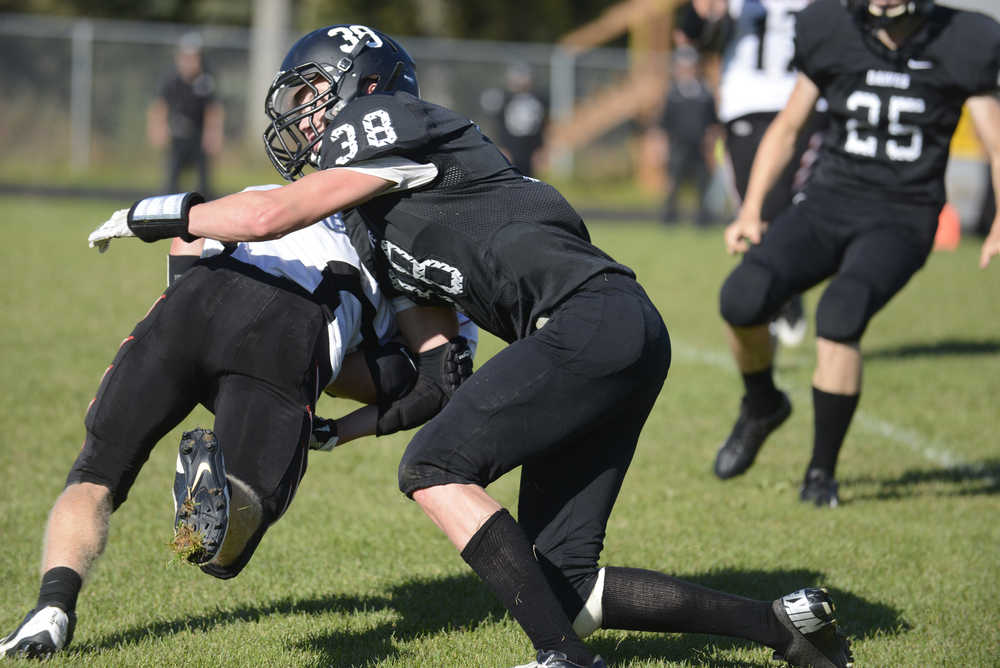 Photo by Kelly Sullivan/ Peninsula Clarion Nikiski Bulldog Dylan Brousard tackles an Eielson Raven, Saturday, September 6, 2014, at Nikiski High School in Nikiski, Alaska.