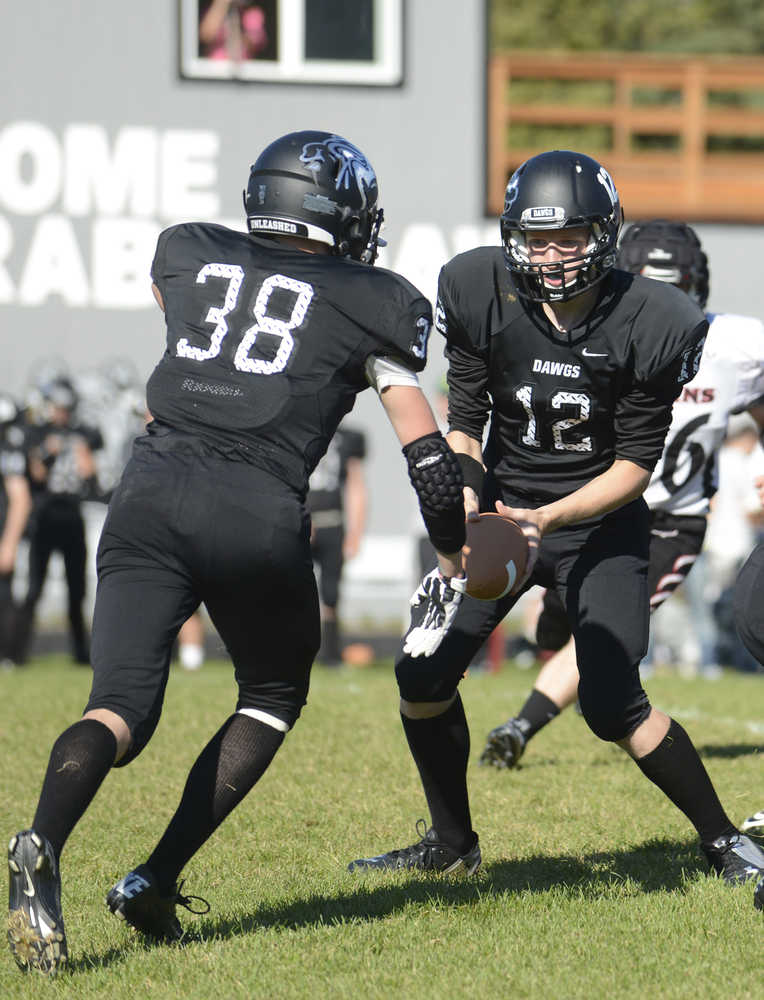Photo by Kelly Sullivan/ Peninsula Clarion Dennis Anderson passes subtly passes the ball to Dylan Brousard during a game against the Eielson Ravens, Saturday, September 6, 2014, at Nikiski High School in Nikiski, Alaska.