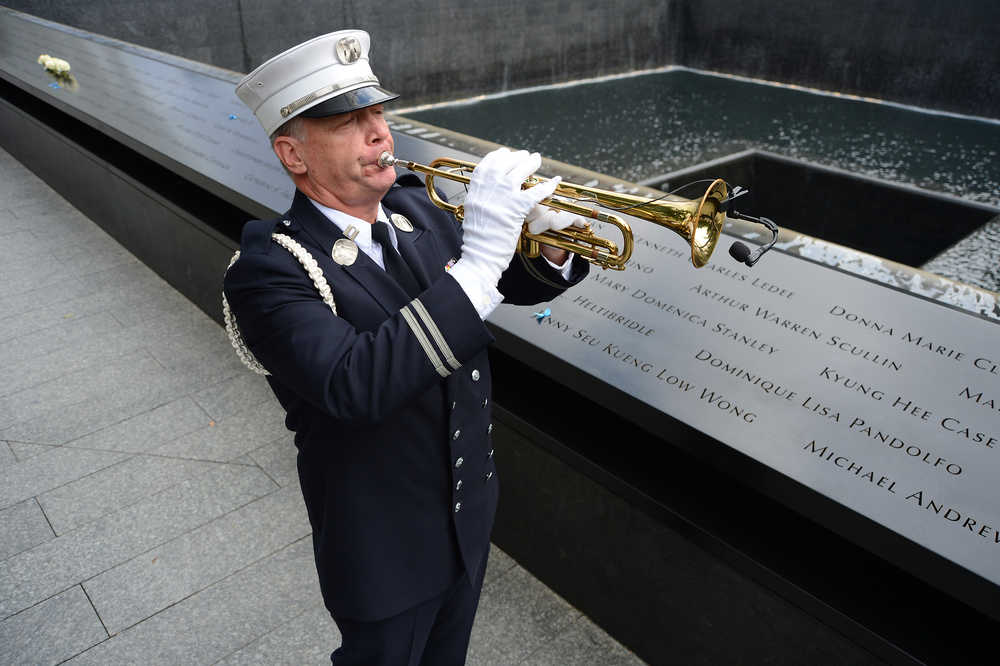 Firefighter Tom Engel with Ladder 133 plays Taps at the end of memorial observances on the 13th anniversary of the Sept. 11 terror attacks on the World Trade Center in New York, Thursday, Sept. 11, 2014.   Family and friends of those who died read the names of the nearly 3,000 people killed in New York, at the Pentagon and near Shanksville, Pennsylvania. (AP Photo/The Daily News, Robert Sabo, Pool)