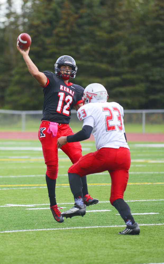 Photo by Kelly Sullivan/ Peninsula Clarion Kenai Kardinals' Jace Baker makes a quick pass before Wasilla Warriors' DJ Morrow can tackel the ball from him, Friday, September 12, 2014 at Kenai Central High School in Kenai, Alaska.