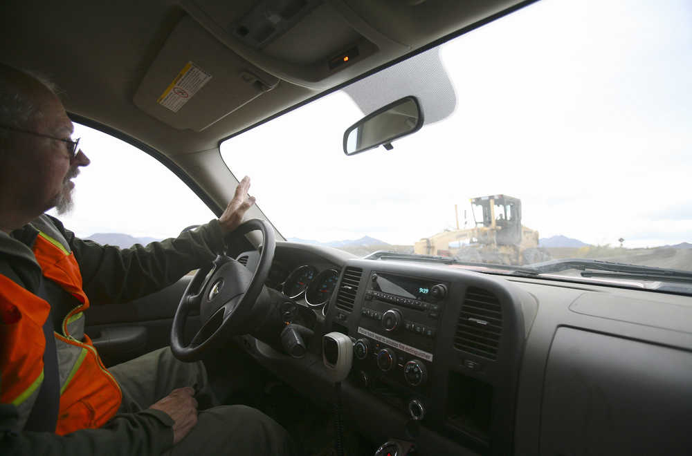 In this photo taken Aug. 28, 2014, road work leader Rick Weibel waves to a road grader while making the rounds to the work sites along the Park Road in Alaska's Denali National Park and Preserve. The workers on the Denali National Park and Preserve road crews spend their time navigating a narrow path between two imposing bodies. The road crew spends each day maintaining the narrow, two-lane road that runs for miles between 6,000-plus foot ridge lines. (AP Photo/Fairbanks Daily News-Miner, Erin Corneliussen)