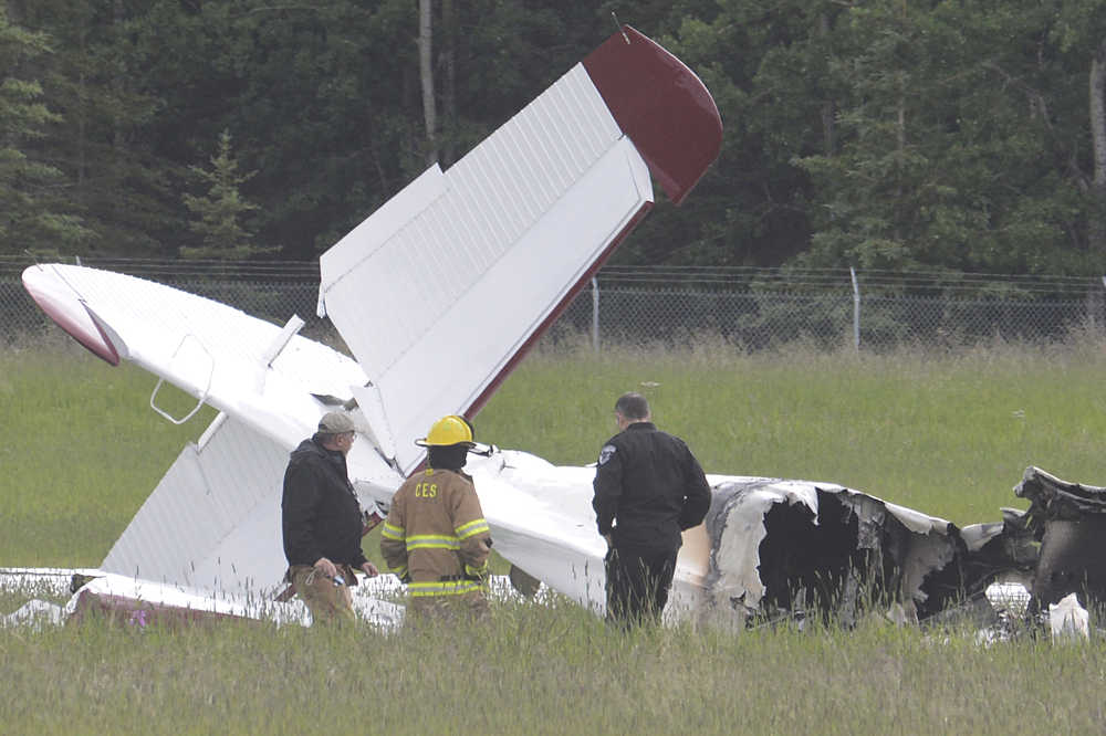 Photo by Rashah McChesney/Peninsula Clarion  Investigators look at the remains of a fixed-wing aircraft that was engulfed in flames Sunday July 7, 2013 at the Soldotna Airport in Soldotna, Alaska. No survivors were located and it is unknown how many people were on board.