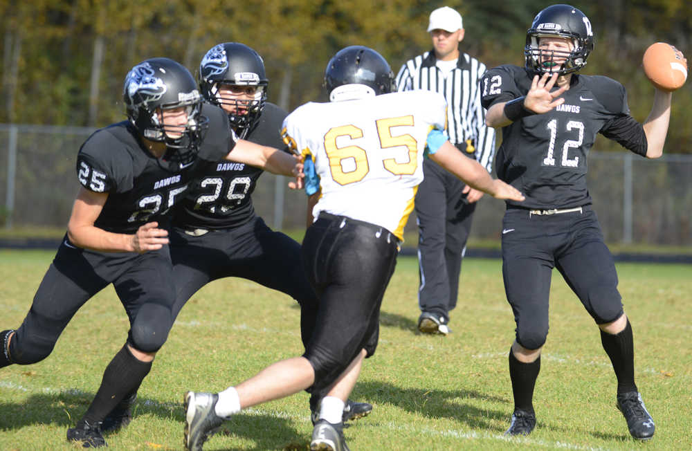 Photo by Kelly Sullivan/ Peninsula Clarion Nikiski Bulldog's Dennis Anderson makes a pass before Voznesenka Cougar's David Kuzmin can intercept, Saturday, September 20, 2014, at Nikiski High School in Nikiski, Alaska.