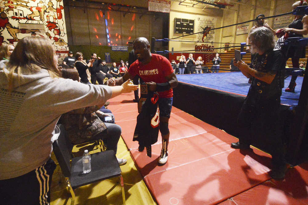 Photo by Kelly Sullivan/ Peninsula Clarion New Frontier Wrestling Alliance Champion Calvin James enters the arena and greets his fans, Saturday, September 20, 2014 during the Kardinals Wrestling Team Fundraiser presented by Power Plant Productions at Kenai Central High School in Kenai, Alaska.