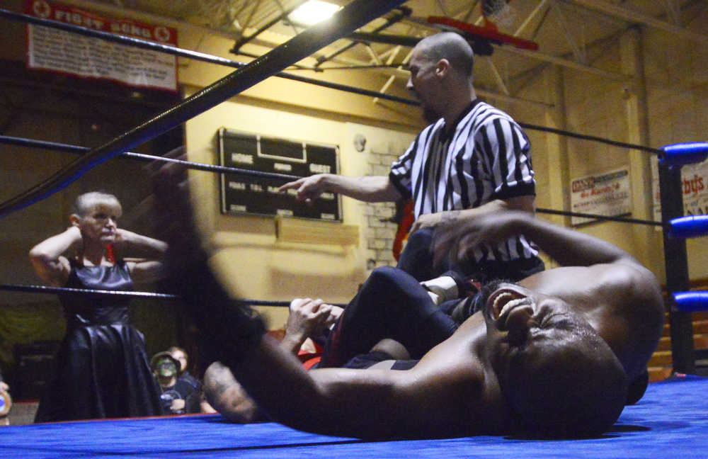 Photo by Kelly Sullivan/ Peninsula Clarion New Frontier Wrestling Alliance Champion Calvin James yells as Mickey "AK Lightning" twists his legs, Saturday, September 20, 2014 during the Kardinals Wrestling Team Fundraiser presented by Power Plant Productions at Kenai Central High School in Kenai, Alaska.