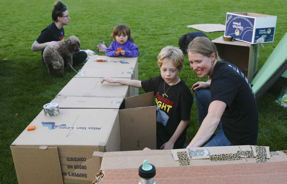 In this photo taken Sept. 13, 2014, Tracyann George shows her son Owen George, 8, one of the cardboard structures they made to sleep in during One Homeless Night in Veteran's Memorial Park in Fairbanks, Alaska. George was one of several dozen who volunteered to spend the night in Veterans Memorial park Saturday to raise awareness of youth homelessness and to raise money for Fairbanks Youth Advocates. The organization operates The Door, a 24-hour shelter at 138 10th Ave. open to any homeless youth younger than 18. (AP Photo/Fairbanks Daily News-Miner, Erin Corneliussen)