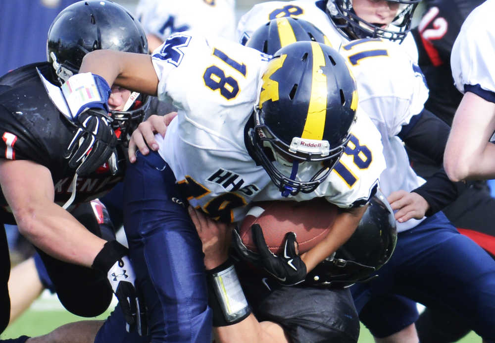 Photo by Kelly Sullivan/ Peninsula Clarion The Kenai Kardinals' take down Homer Mariner's Eric Hill, Saturday, September 27, 2014, at Kenai Central High School in Kenai, Alaska.