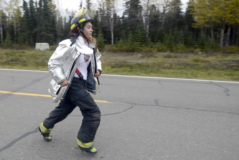 Photo by Rashah McChesney/Peninsula Clarion (left) Chugiak Volunteer Fire and Rescue firefighter Joe Lindquist hands a stretcher to Tell Spragg, firefighter with the Petersburg Fire Department as the two work to pull a mock victim out of a wrecked car Friday September 26, 2014 during the 2014 Alaska Fire Conference. Dozens of firefighters opted for a 2-day extrication training class held at the Reddi Towing and Salvage yard in Kenai, Alaska.