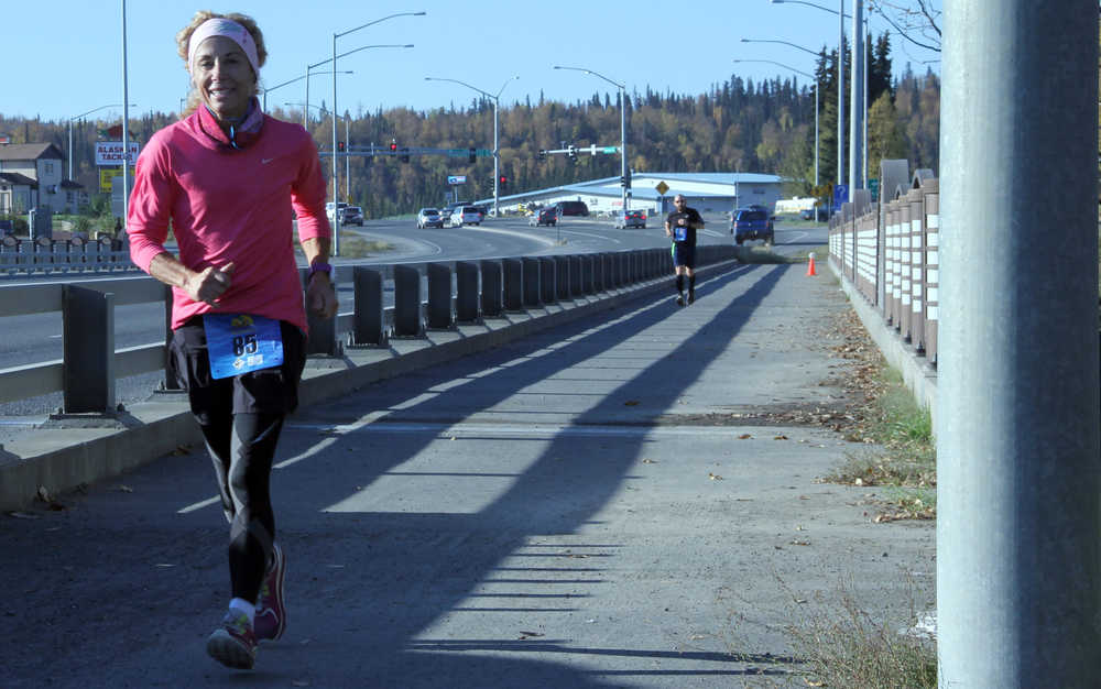 DeeDee Jonrowe, of Willow, runs across the David Douthit Veterans Memorial Bridge in Soldotna during the Kenai River Marathon on Sunday. Photo by Kaylee Osowski/Peninsula Clarion