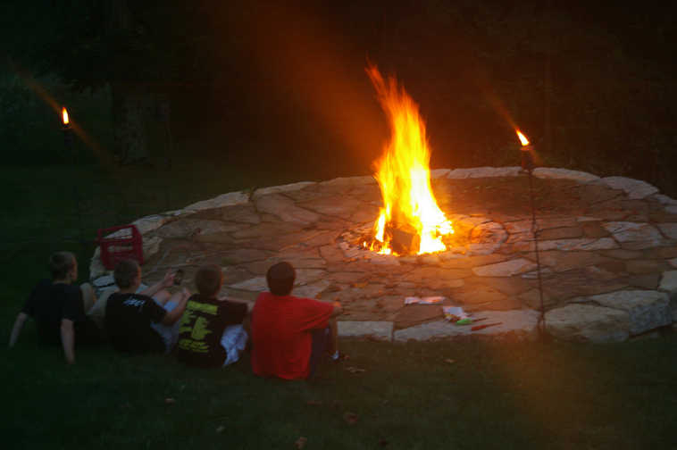 This 2014 photo provided by Susan Vanderwiel shows shows the fire pit she and her family enjoy year-round at their lake house in Apple River, Ill. Vanderwiel is one of a growing number of homeowners who are using outdoor living spaces year-round thanks to features from fire pits and pizza ovens to heated floors and three-wall rooms. (AP Photo/Sue Vanderwiel)