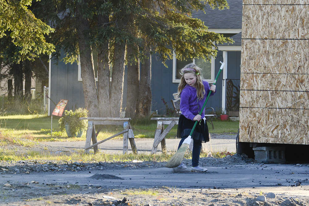 Photo by Rashah McChesney/Peninsula Clarion  Alika Hammerle, sweeps a concrete pad near Sedona Florist Wednesday Oct. 1, 2014 in Soldotna, Alaska.