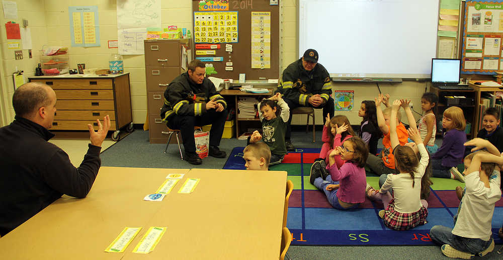 Photo by Dan Balmer/Peninsula Clarion Kenai firefighters Pete Coots, (left) Dustin Voss and Capt. John Harris share fire safety tips with kids Thursday in Mandi Vaala's first grade class at Mountain View Elementary School in Kenai.