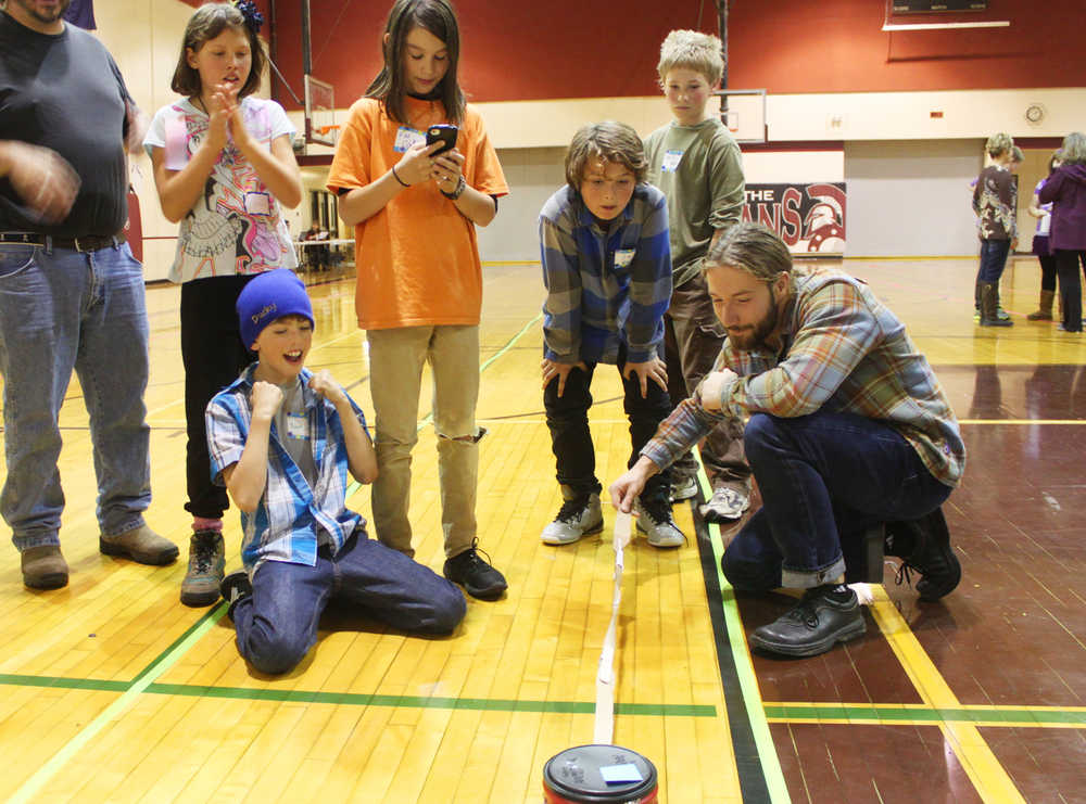 Photo by Kelly Sullivan/ Peninsula Clarion Members of the Fireweek Academy's Mind Amazes team, the District 12 los locos, react with excitement as Quinn Stoops, a substitue teacher in the Kenai Peninsula Borough School District, successfully tests the strength of the team's "rope" in the "spontaneous problem" portion of the competition Saturday, October 11, 2014, at Soldotna Prep School in Soldotna, Alaska.