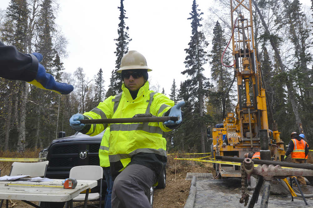 Photo by Rashah McChesney/Peninsula Clarion  Luis Ferreira, geotechnical engineer, passes a soil sample to a representative of the Alaska LNG project from a site near Autumn Street in Nikiski Thursday Oct. 9, 2014 in Nikiski, Alaska. Alaska LNG is conducting geotechnical surveys in an area where they plan to put an LNG facility.