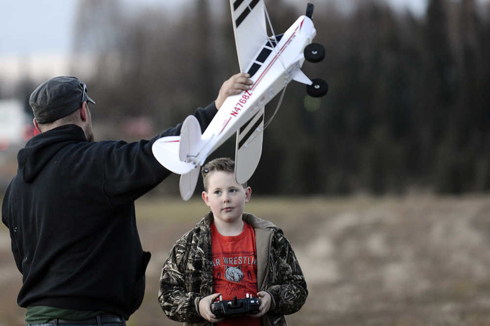 Photo by Rashah McChesney/Peninsula Clarion  Nathan Warren, of Soldotna, talks about the physics of launching a plane to Alston Thomas, 10 Wednesday October 15, 2014 in Soldotna, Alaska.