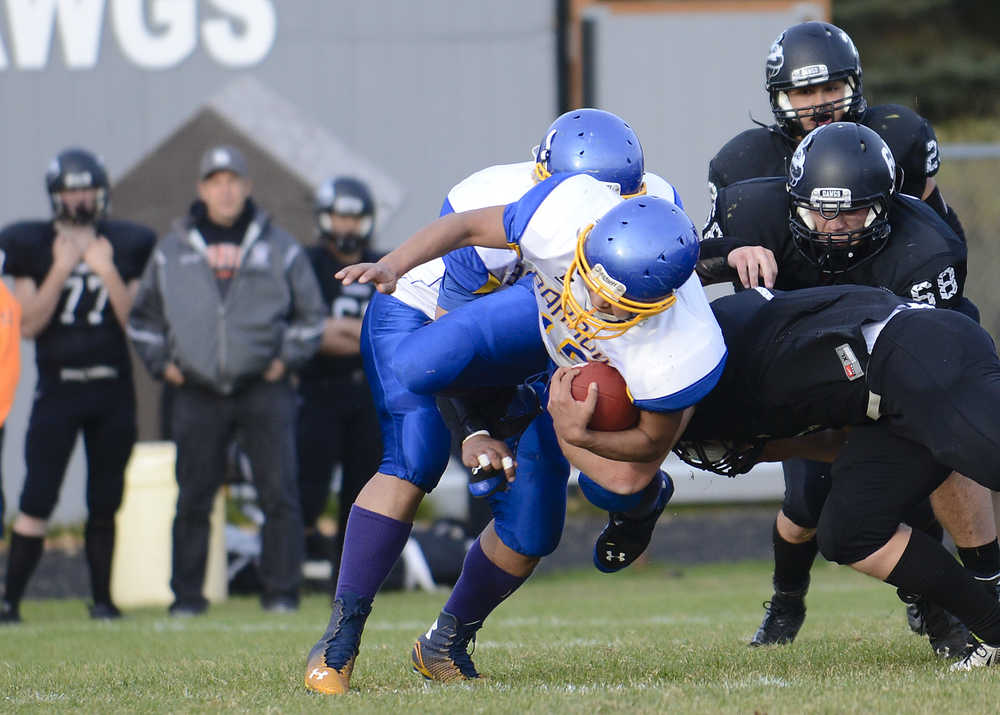 Photo by Rashah McChesney/Peninsula Clarion Barrow Whaler David Elavgak is swept off his feet for a tackle during a game against the Nikiski Bulldogs Friday September 26, 2014 in Nikiski, Alaska.