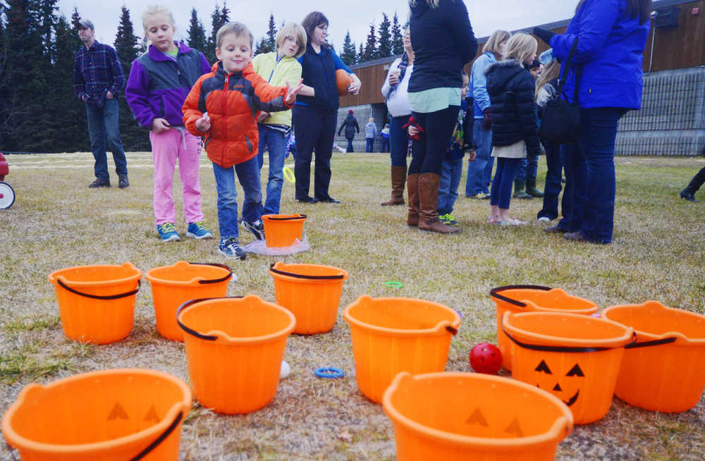 Photo by Kelly Sullivan/ Peninsula Clarion Hunter Richmond plays a ring toss game while his sister Grace Richmond watches from behing at the first "Pumpkins in the Playground," event Thursday, October 16, 2014, at Kalifornsky Beach Elementary in Soldotna, Alaska.