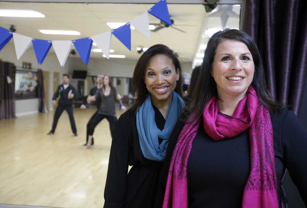 CORRECTS TO CLARIFY THAT LOVE IS NOT YET A BUSINESS PARTNER - In this Tuesday, Sept. 30, 2014 photo, Fred Astaire Dance Studio owner Andrea Bisconti, right, poses on the dance floor with instructor Kellie Love, in Willoughby, Ohio. Faced with the prospect of losing Love, who wanted to start her own studio, Bisconti is negotiating to make her a business partner. They are now looking to take over a studio that's up for sale. (AP Photo/Mark Duncan)