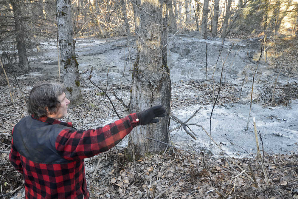 Photo by Rashah McChesney/Peninsula Clarion  A stream of discharge runs down a dirt hill behind a Baker Hughes facility Thursday October 23, 2014 in Nikiski, Alaska. A company spokesperson said the material is cement, but an adjacent property owner whose land has been affected by the runoff said the pungent odor of material left behind indicates otherwise.