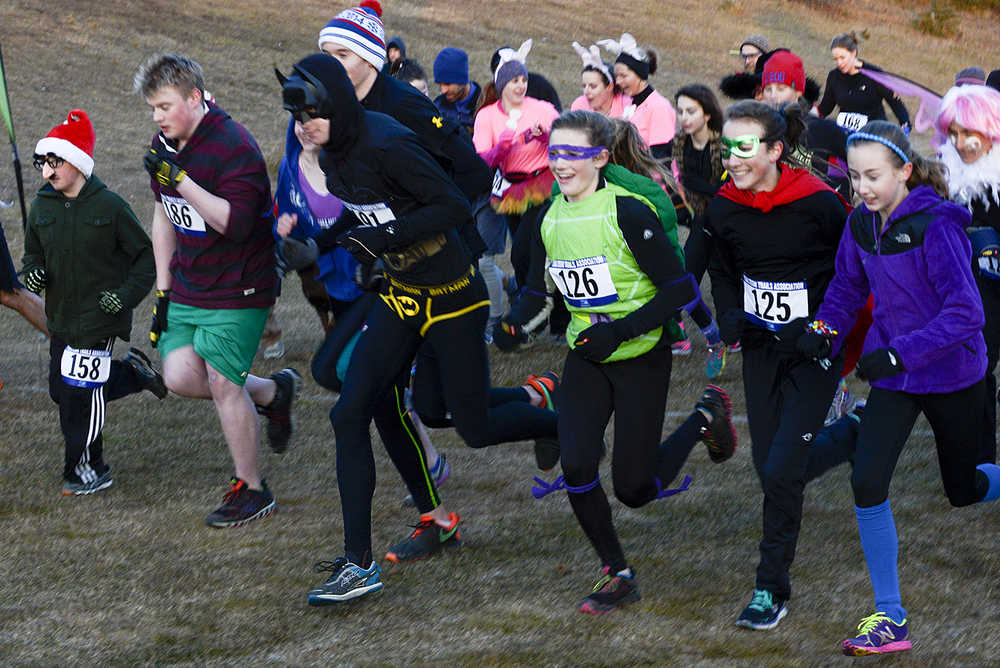 Photo by Rashah McChesney/Peninsula Clarion  Dylan Hogue, 11, pulls ahead of his father Doug Hogue, both of Soldotna, during the Tsalteshi Trails Association's Spook Night Fun Run on Sunday October 26, 2014 in Soldotna, Alaska.