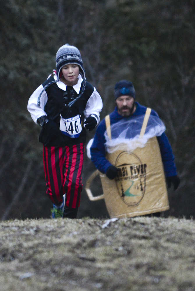 Photo by Rashah McChesney/Peninsula Clarion  (left) Penelope Priest, 3, Marie Priest and North Priest, 3, walk down a hill at the Tsalteshi Trails after trick-or-treating during the Tsalteshi Trails Association's Spook Night on Sunday October 26, 2014 in Soldotna, Alaska.