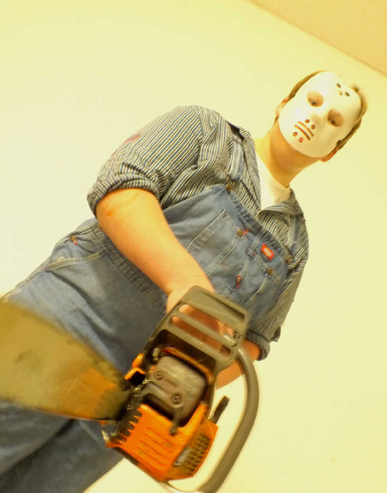 Ben Boettger/Peninsula Clarion Stockton Jones plays a chainsaw killer at the Soldotna High School Drama Troupe's haunted house fundraiser, Tuesday October 28, 2014, at the Peninsula Center Mall