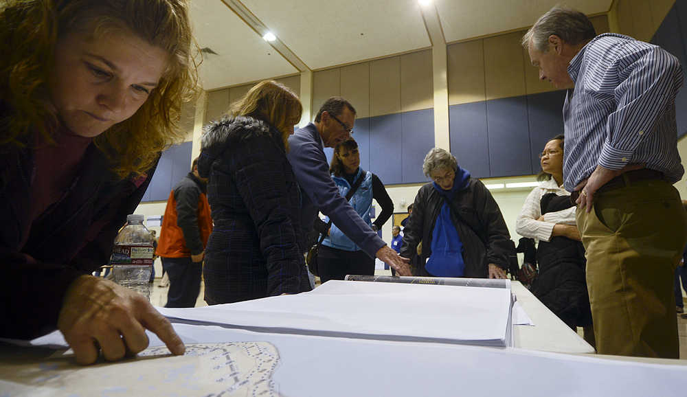 Photo by Rashah McChesney/Peninsula Clarion Katrina Nelson, of Nikiski, looks for home on a map depicting the study corridor for a potential right-of-way for the AlaskaLNG pipeline on October 28, 2014 during an open house in Nikiski, Alaska.